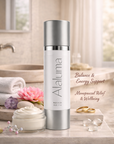Alaluma skincare bottle on a bathroom counter with flowers and towels in the background